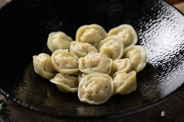 Appetizing traditional Russian dumplings, handmade. Still life on a wooden board. Close-up.