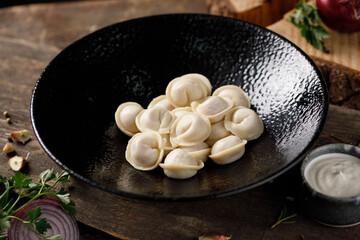 Appetizing traditional Russian dumplings, handmade. Still life on a wooden board. Close-up.