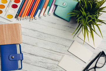 glasses on the table business cards coffee with a notebook solarium markers flower in a pot