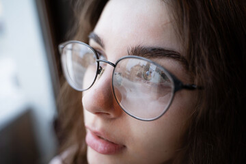 portrait of a girl in round glasses for vision and curly hair