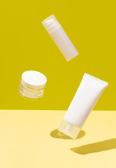 Creative layout with levitating beauty products on yellow background