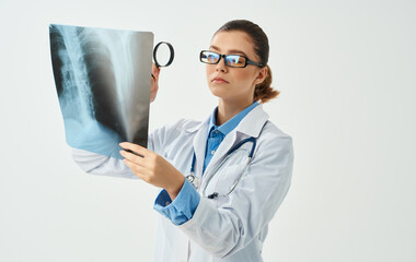 Woman with x-ray is holding a magnifying glass in hand doctor medicine nurse