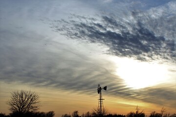 Windmill at Sunset with a colorful sky north of Hutchinson Kansas USA out in the country.