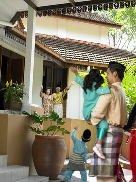 Family Waving While Standing Outside House