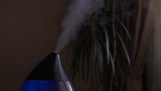 Steam from a modern air humidifier in dark room. Close-up, no people.