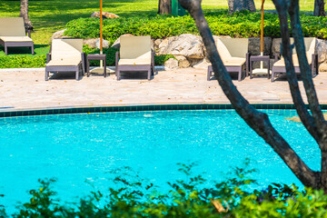 Outdoor swimming pool with sea ocean beach around umbrella and chair