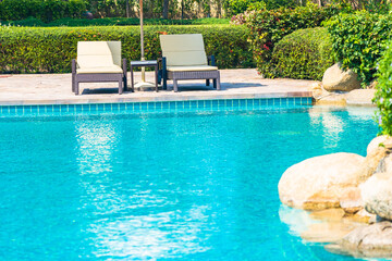 Outdoor swimming pool with sea ocean beach around umbrella and chair