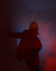 young woman in dark. yellow and blue lights. defocus