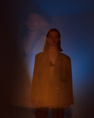 young woman in dark. yellow and blue lights. defocus