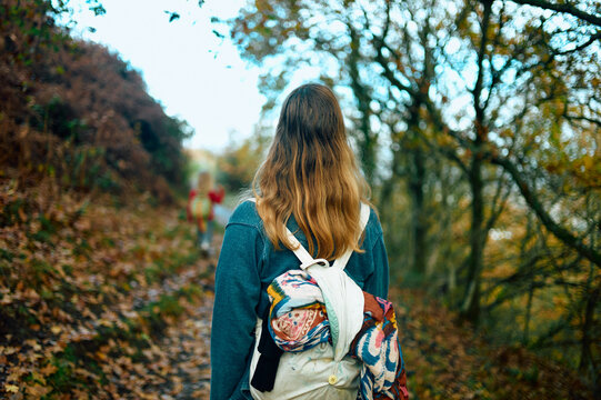Young woman walking on a path in the woods on an autumn day