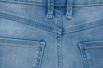 Backside denim blue jeans pocket closeup. Denim jeans texture. Blue jeans texture with pocket for any background. High quality photo