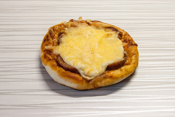 A small pizza with sausage and cheese.