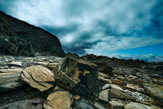 Rocks on the beach against dramatic sky