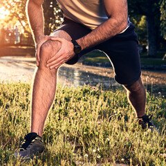 Sports jogging running injury in the park, young man having knee pain problem.