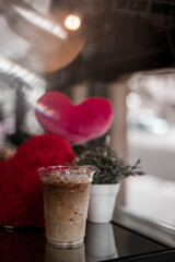 Obraz na płótnie Canvas glass of coffee with milk on the table, valentine theme