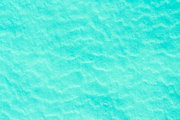 blue texture of an ice surface covered with snow ,cold clear cryslallized wall background ,winter frozen surface close up , abstract macro wallpaper