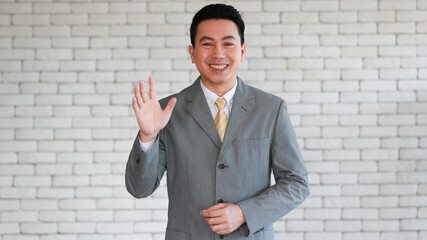 Portrait of a senior elegant standing lean wall and looking businessman in a grey polite suit...