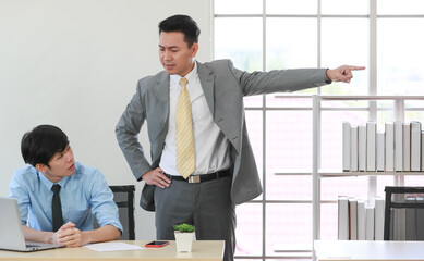 Executive boss Asian businessman in suit standing with anger and pointing finger action as give get fired for young employee due to his low-quality work
