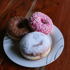 Ein Berliner Krapfen, ein rosafarbener und ein brauner Donut - A Berlin donut, a pink and a brown donut