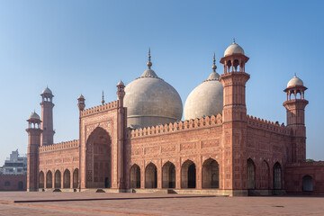 Side view of beautiful ancient Badshahi mosque with courtyard built by mughal emperor Aurangzeb a landmark of Lahore, Punjab, Pakistan - obrazy, fototapety, plakaty