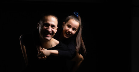 father and daughter on black background