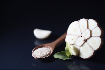 Fresh garlic clove on black background. Garlic is rich in vitamins, useful spring, good spices. Garlic sliced on a dark background. Raw sliced garlic.