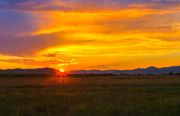 July sunset at the end of a summer day painted the sky in golden shades