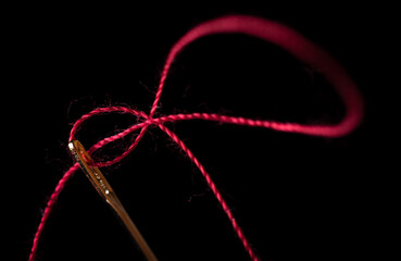 needle and thread on a black background	