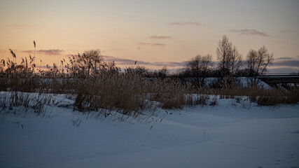 Beautiful rural winter scene with bridge, trees, ice and snow covered river. Winter outdoors nature scene. Beautiful  rural landscape