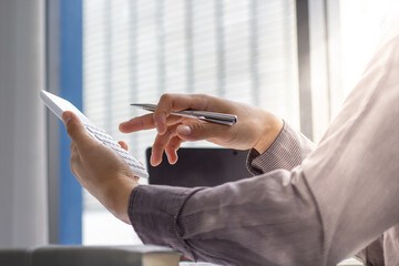 businessman working on desk office with using a calculator to calculate the numbers, finance accounting concept