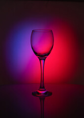silhouette of transparent  glass  on red  and purple background