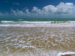 waves on the sand beach with blue sky
