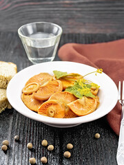 Mushrooms salted in plate with bread on black board