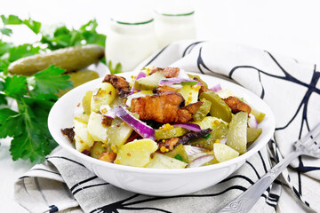 Salad potato with bacon and cucumber in plate on white board