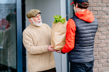Old man meeting food delivery man. Seniors with gray beard and mustache