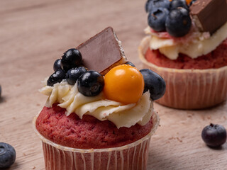 Sweet homemade cupcakes with blueberries and cream mousse. Surrounded by blueberries. Cooking baked goods at home. High quality photo