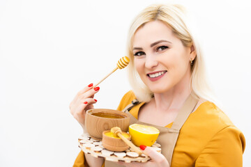 Happy young woman holding wooden bowl of honey, copy space