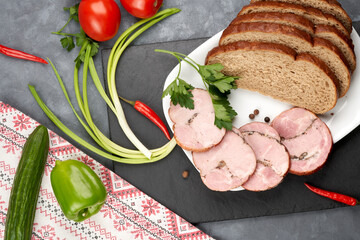Pieces of boiled pork on a plate with bread and herbs. Delicious meat appetizer.