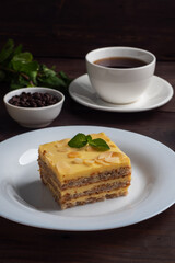 Banana sponge cake with nuts and mint. Delicious sweet dessert for tea, Dark wooden background.