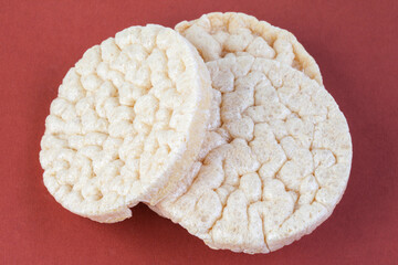 Round crunchy crispbreads on a pink background. Round shaped cereal bread, healthy food without yeast. puffed multigrain crisp-breads for diet.