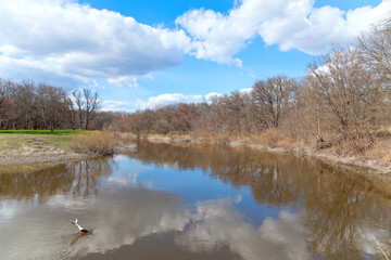 Spring forest and blue sky reflected in the river Samara.