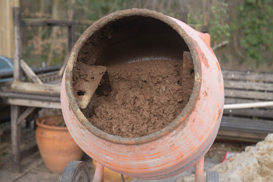 Mixing a Floor Screed in the Drum of a Rusty Old Cement Mixer on a Building Site in Rural Devon, England, UK
