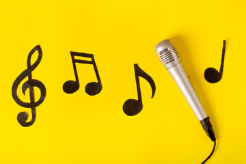 musical notes and microphone on a yellow background.