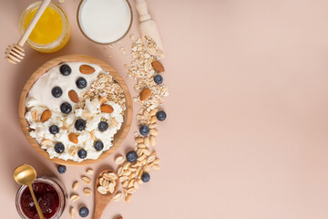 Curly leaves of parsley and a bowl of curd cream on a white table.
