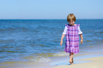 Beautiful girl in a dress walking on the beach