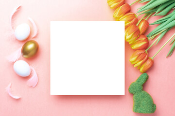 Easter egg hunt. Golden, white colour egg in basket with spring tulips, feathers on pastel pink background in Happy Easter decoration. Traditional design in top view.