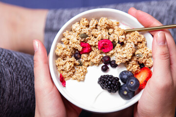 Granola bowl with unrecognizable woman