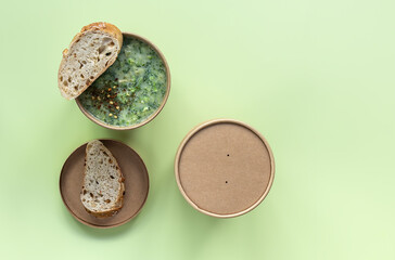 Fresh broccoli cream soup served fresh bread and spices in craft container. Vegetarian lunch to go.