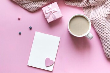 Flat lay composition of valentine's day. Pink pastel background with a card for text, coffee in a cup and with a gift