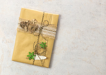 Book wrapped in craft paper with wooden decorations. Zero waste, eco friendly packaging gift.